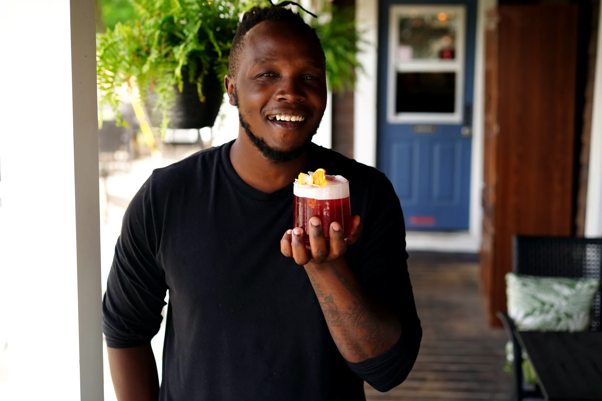 Bartender holding a seasonal cocktail at SoLo on Main