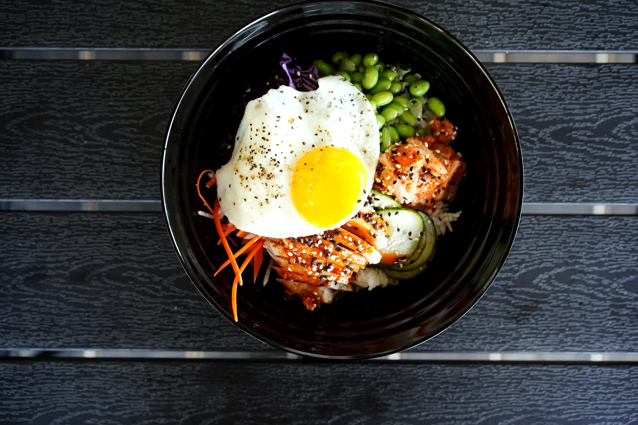 Chicken rice bowl with kimchi, edamame, cucumber, and fried egg at SoLo on Main