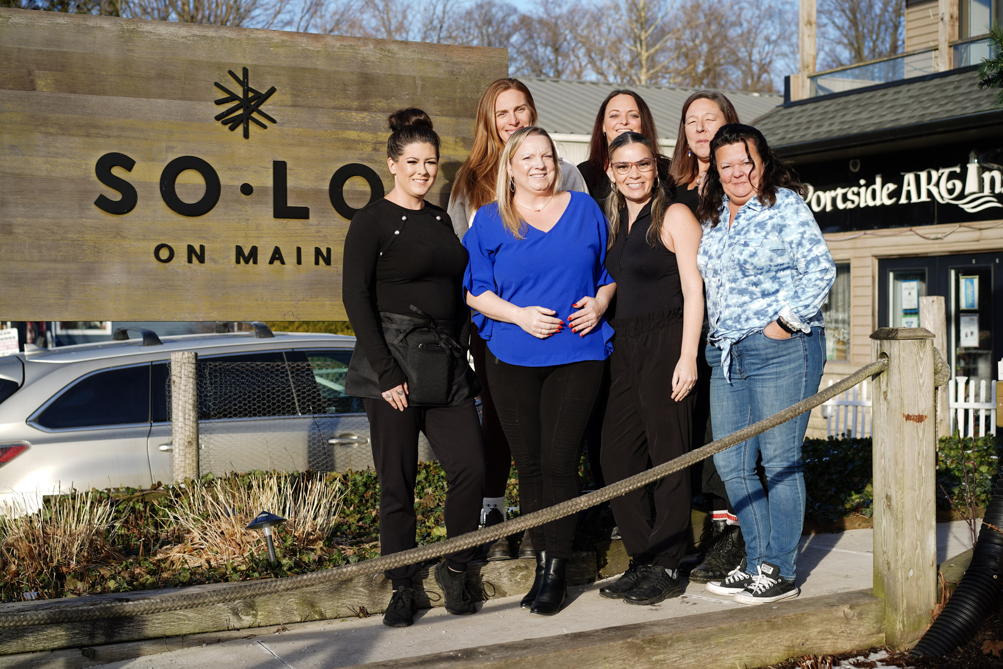 SoLo on Main team gathered beside the restaurant sign in Port Stanley